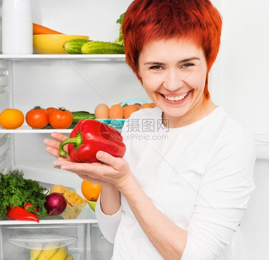 妇女对冰箱的反对红色绿色生活胡椒辣椒微笑厨房成人女士幸福图片