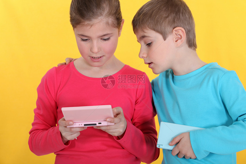 哥哥和姐姐玩电子游戏蓝色享受女孩控制控制器眼睛游戏闲暇孩子电脑图片