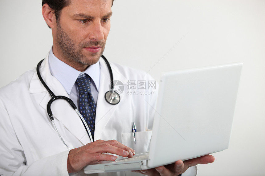 持有膝上型电脑的医生工作笔记本工作室医疗衬衫白色医院阅读男人图片