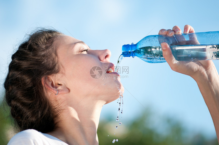 美丽的妇女饮用水 干渴活力口渴闲暇女性快乐重量运动员慢跑天空女士图片