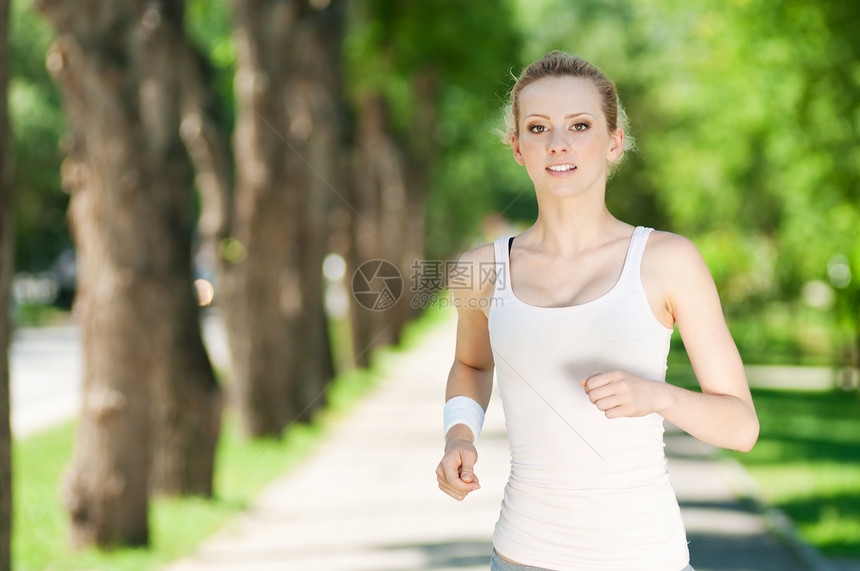 青年女子在绿色公园中奔跑慢跑行动女孩慢跑者活力活动运动女士快乐跑步图片