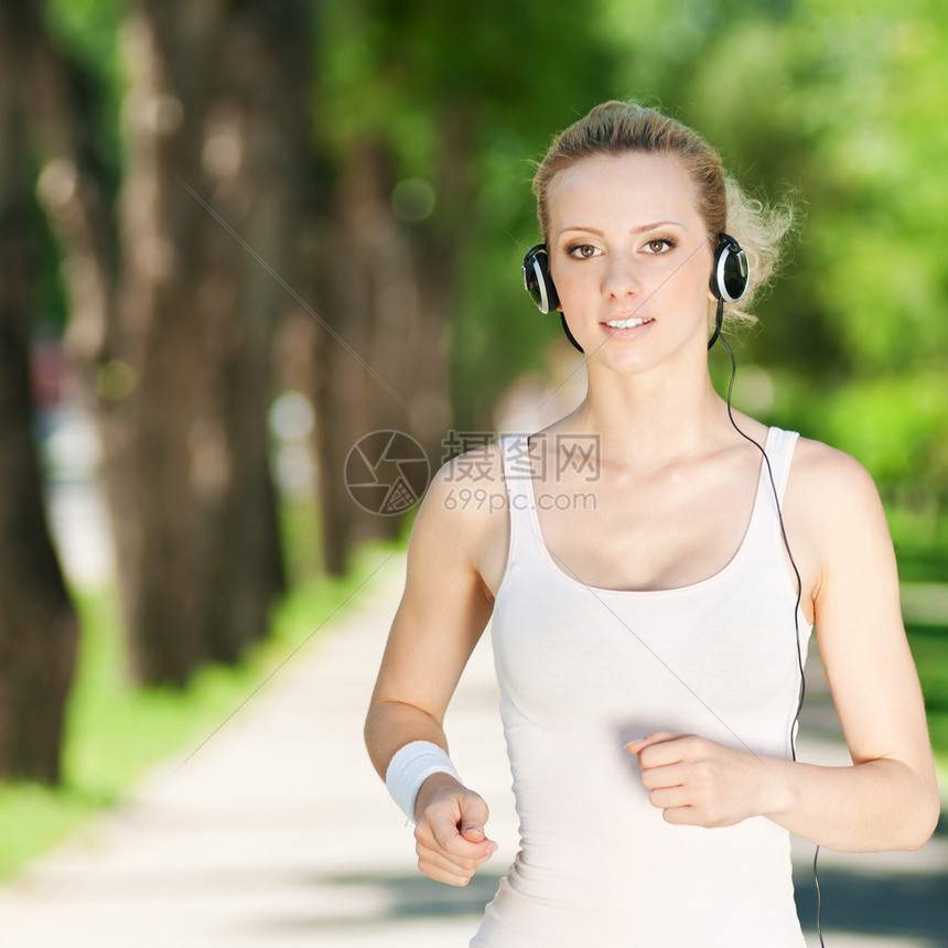 青年女子在绿色公园中奔跑闲暇活动女性音乐慢跑者活力快乐公园慢跑训练图片