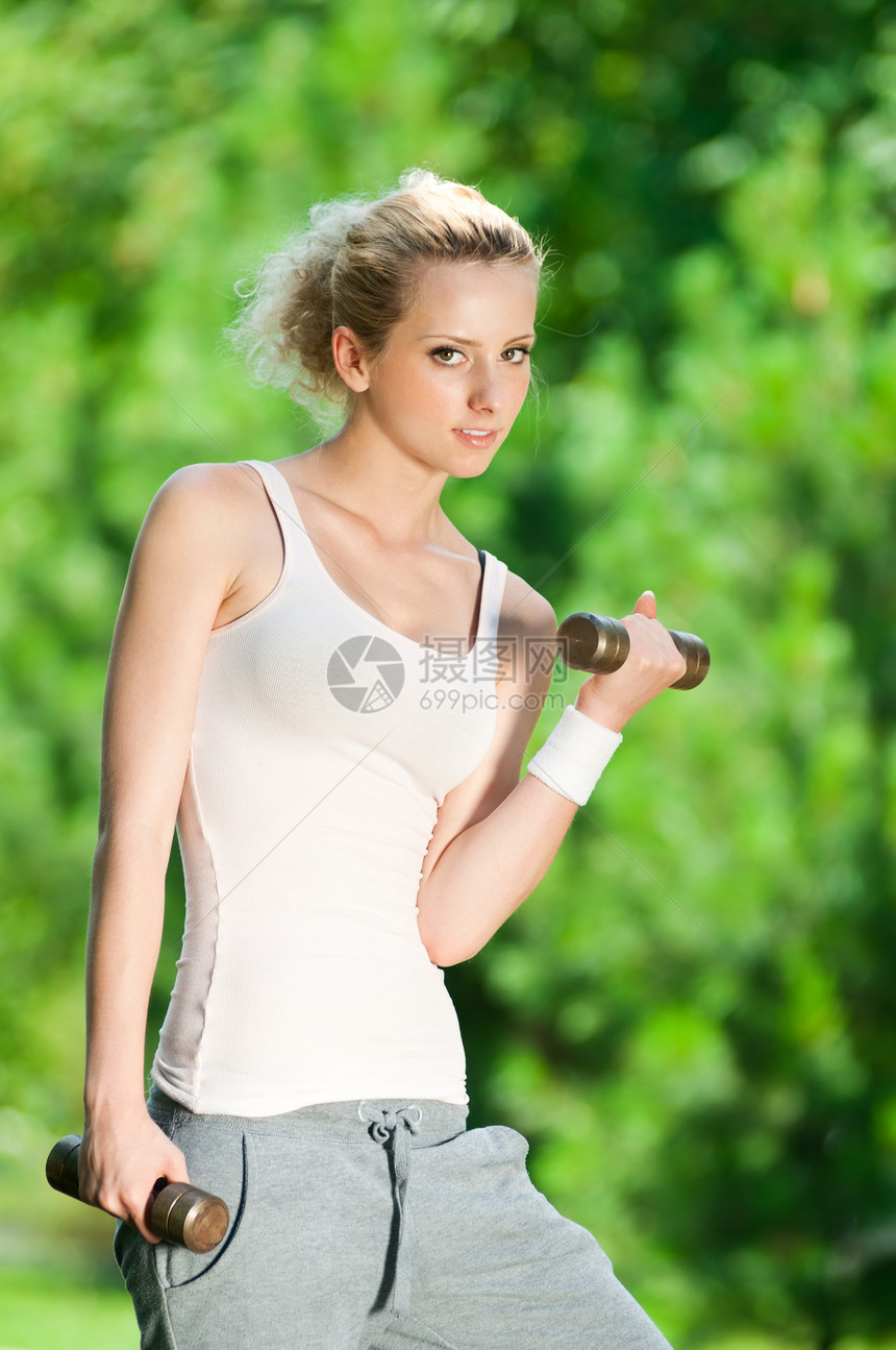 在户外做哑铃运动的妇女重量季节力量行动金属女性闲暇训练街道公园图片