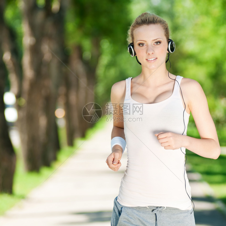 青年女子在绿色公园中奔跑季节跑步闲暇运动姿势女士行动音乐训练肌肉图片