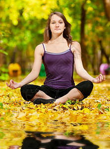 在秋季公园做瑜伽锻炼的妇女女性卫生叶子喜悦季节镜子花园平衡森林冥想图片
