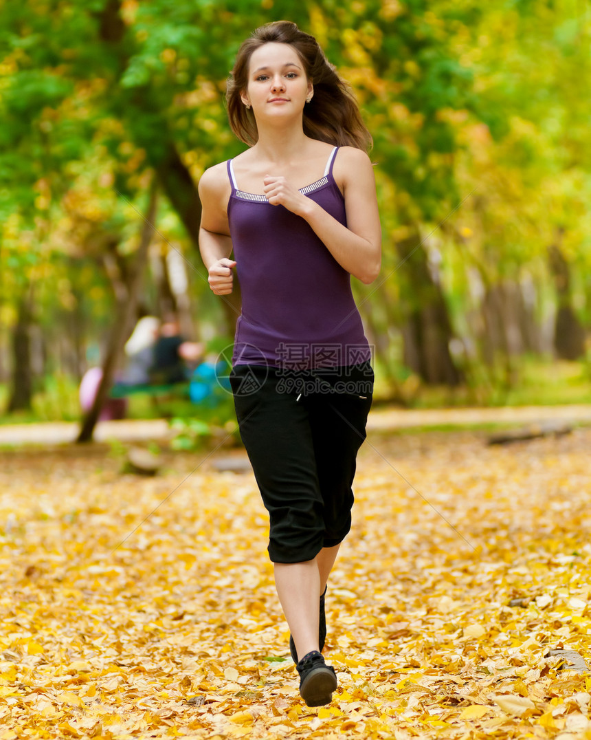 一个年轻女孩在秋天公园奔跑跑步森林成人女士火车公园女性慢跑越野运动图片