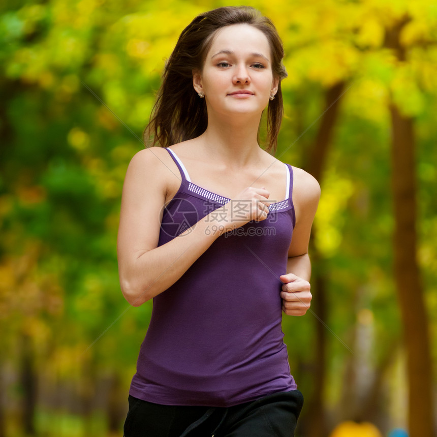 一个年轻女孩在秋天公园奔跑跑步运动装城市活力森林寒冷娱乐火车闲暇女士图片