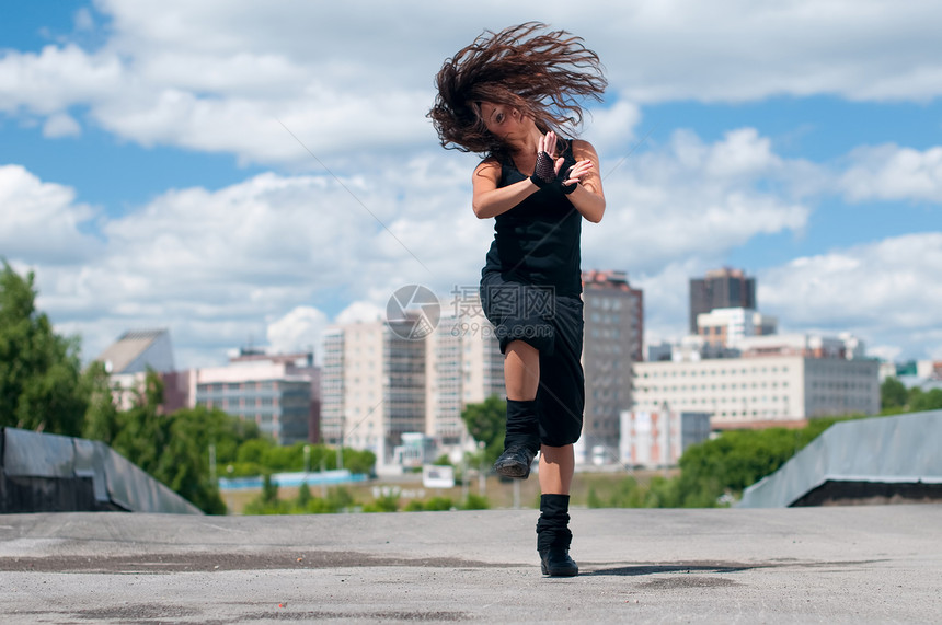 美丽的女孩在城市风景中跳嘻哈舞女性头发成人运动快乐女士天空街道霹雳舞魅力图片