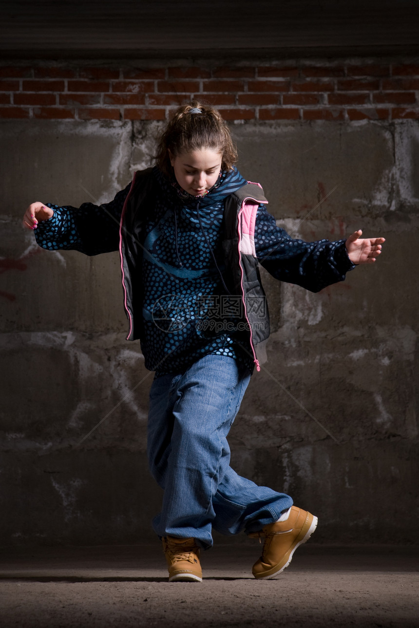 在砖墙上跳现代风格的Hipop舞者女士说唱运动夜生活特技牛仔裤青少年女孩蓝色舞蹈家图片