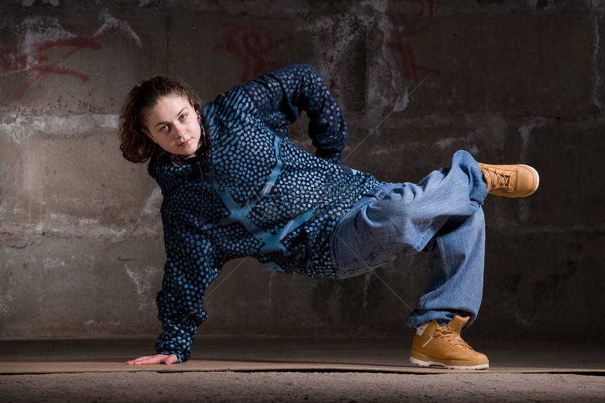 在砖墙上跳现代风格的Hipop舞者街道青少年运动蓝色培训师演员靴子女士女孩霹雳舞图片
