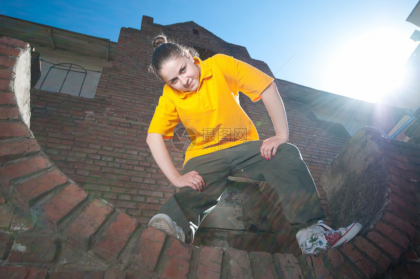红砖墙上的青少年嘻哈女孩舞蹈家光束太阳射线霹雳舞街道橙子城市说唱成人图片