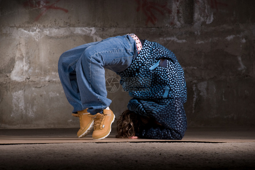 在砖墙上跳现代风格的Hipop舞者霹雳舞牛仔裤舞蹈家情感靴子夜生活蓝色衣服运动说唱图片