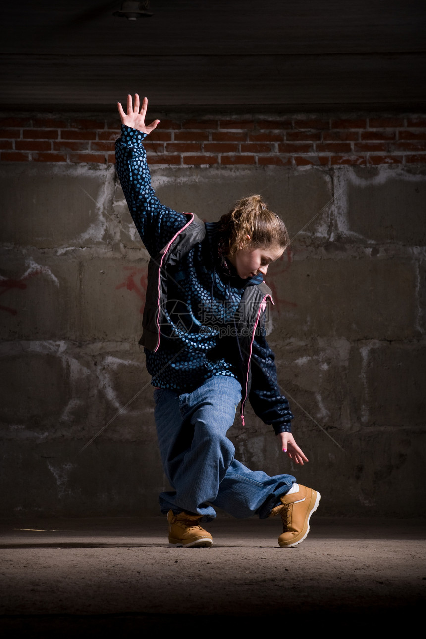 在砖墙上跳现代风格的Hipop舞者舞蹈家青少年演员黑发情感运动特技霹雳舞女孩培训师图片