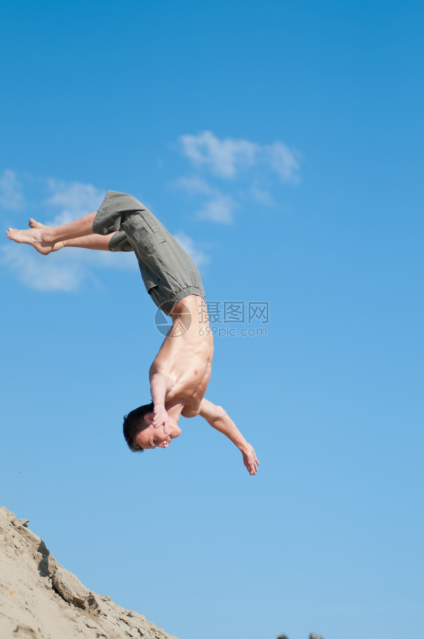 兴奋的年轻人在空气中跳跃喜悦快乐生活成人风险岩石行动悬崖男性天空图片
