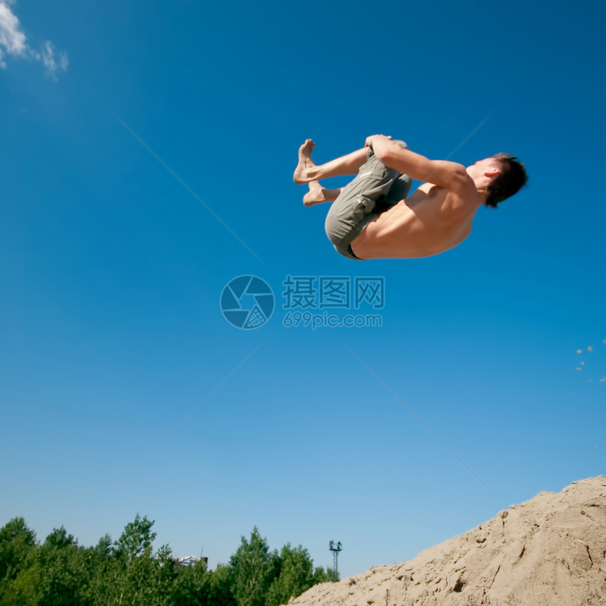 兴奋的年轻人在空气中跳跃蓝色享受风险喜悦男生悬崖生活男性幸福情感图片