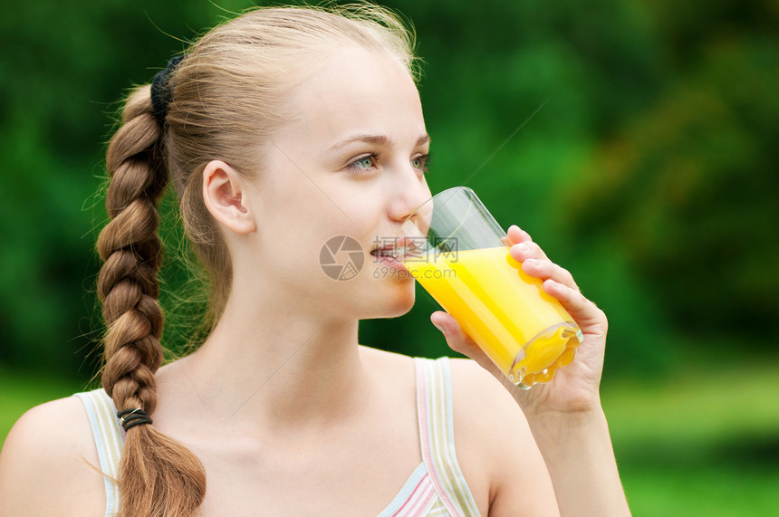 年轻女孩喝橙汁 外门闲暇橙子运动口渴快乐卫生乐趣女性慢跑公园图片
