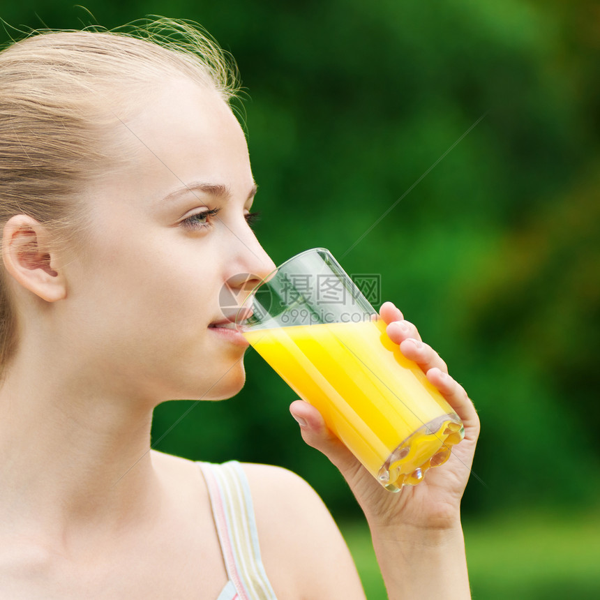 年轻女孩喝橙汁 外门有氧运动果汁蓝色玻璃运动员慢跑卫生公园食物成人图片