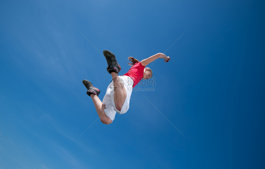 美丽的女人跳上天空运动员深色闲暇快乐蓝色叶子跳跃运动长发自由图片