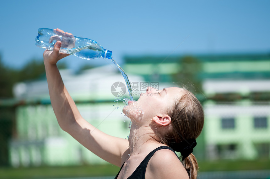 年青妇女锻炼后饮用饮用水成人女孩闲暇女士青少年女性流动快乐运动瓶子图片