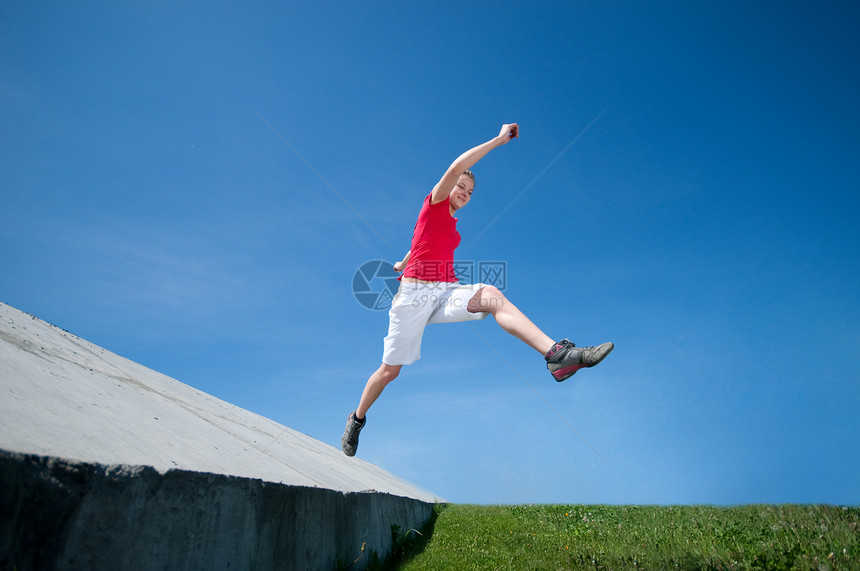 美丽的女人跳上天空叶子活力蓝色青少年长发跳跃自由运动员女性运动图片