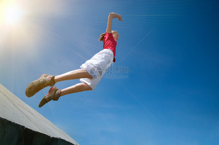 美丽的女人跳上天空射线太阳长发女士深色成人运动员光束运动活力图片