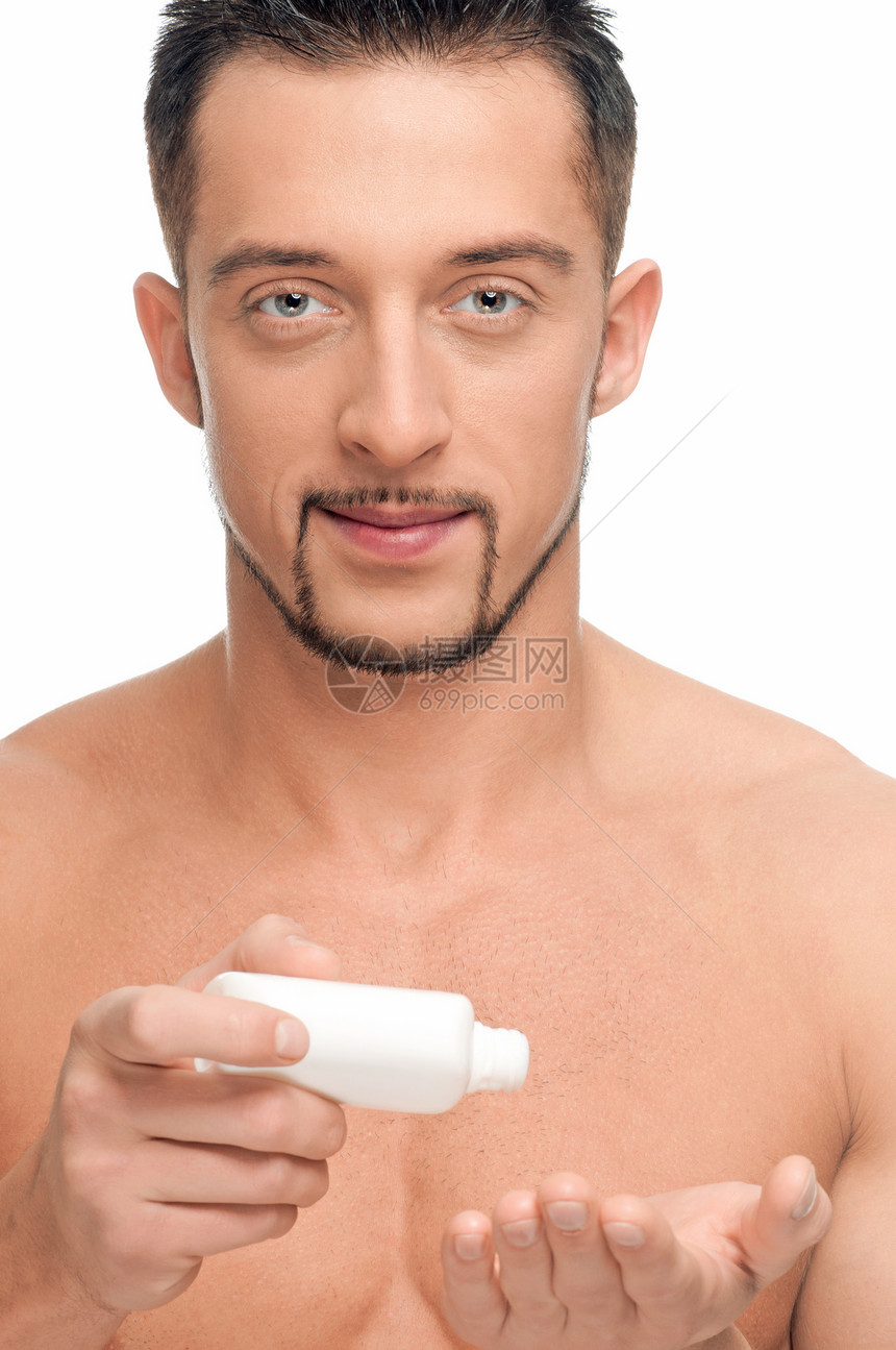 年轻男子施用奶油 化妆品小伙子除臭剂均衡卫生瓶子男人青年护理眼睛力量图片