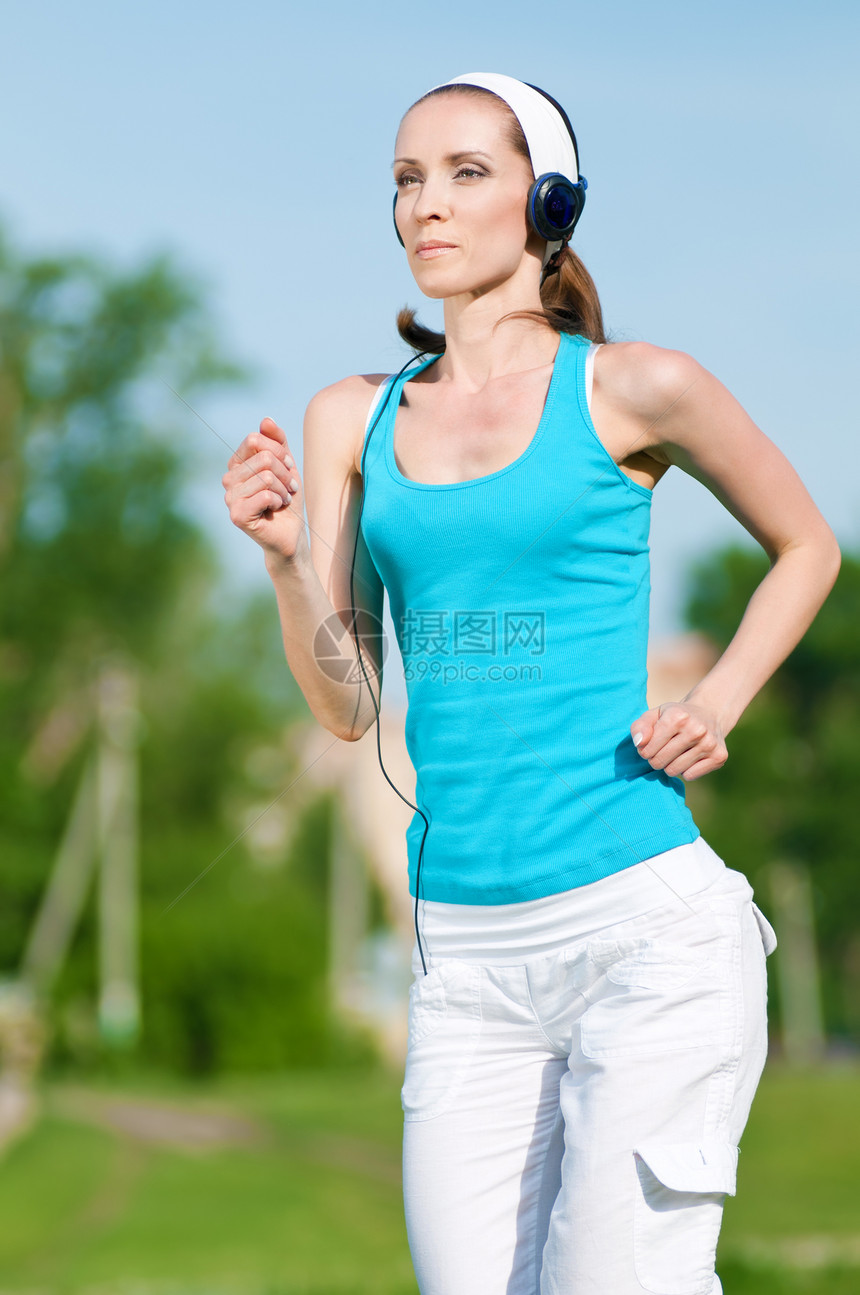 美丽的女子在绿色公园中奔跑活力姿势街道森林女士身体运动装跑步娱乐专注图片