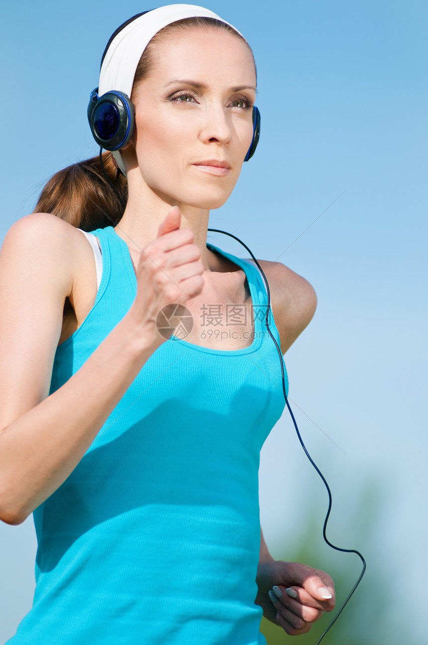 美丽的女子在绿色公园中奔跑音乐专注活力快乐跑步精力公园女孩女士赛跑者图片