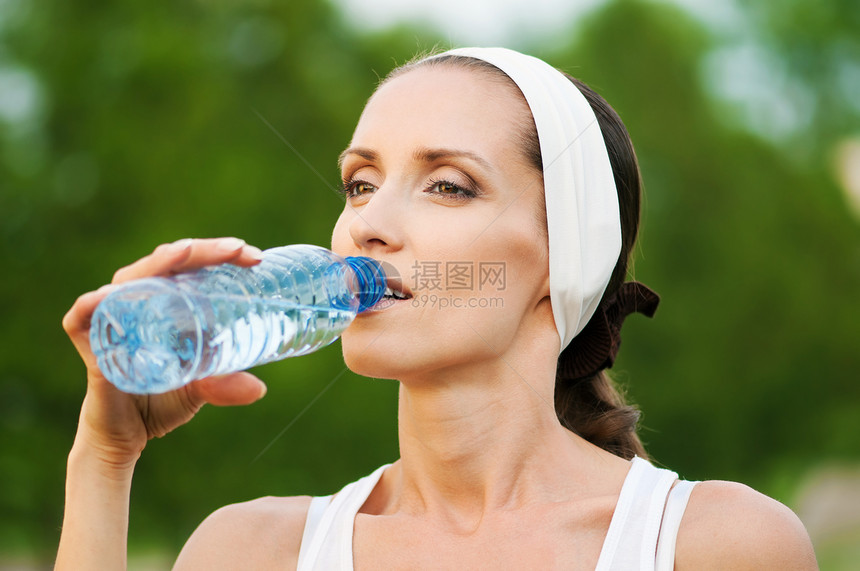 户外运动中的妇女饮用水赛跑者瓶子闲暇公园流动慢跑女性运动装火车运动图片