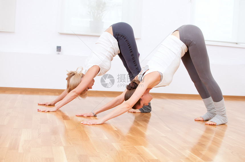 在健身房做瑜伽锻炼的妇女运动装活力朋友有氧运动培训师闲暇专注女性身体调解图片