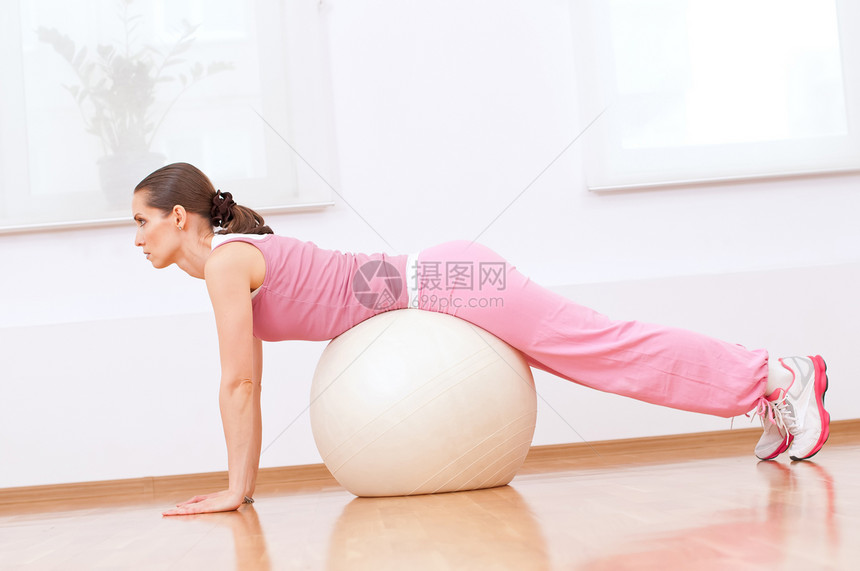 女性在球上做伸展运动娱乐身体调解瑜伽力量微笑健身房女士有氧运动体操图片