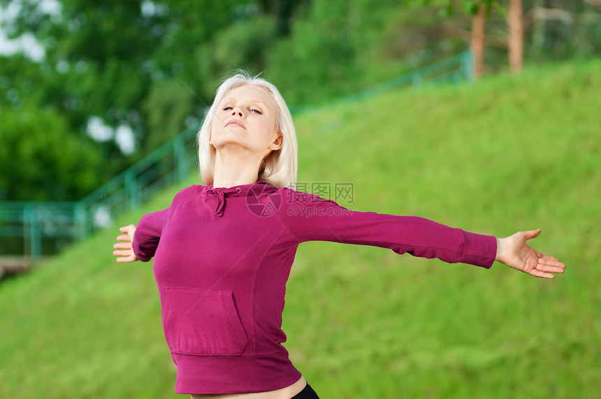 做瑜伽伸展锻炼的漂亮女人闲暇精力幸福头发运动叶子女士慢跑者公园街道图片