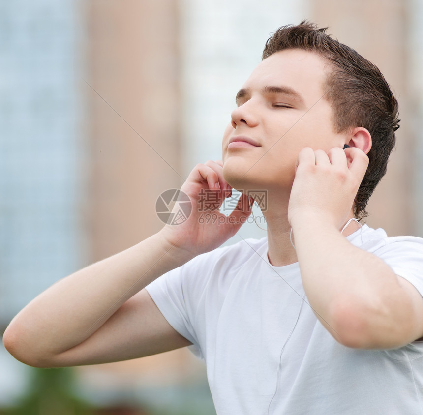 有耳机的有吸引力的年轻人天空公园男生青年乐趣喜悦音乐生活娱乐蓝色图片