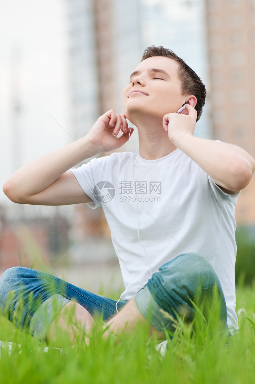 有耳机的有吸引力的年轻人生活男人青少年日光浴假期乐趣娱乐街道音乐蓝色图片