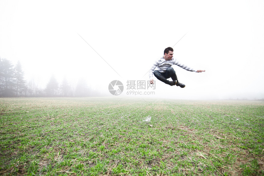 在雾田中男人薄雾场地农业特技橡皮水靴树木雨鞋干草图片