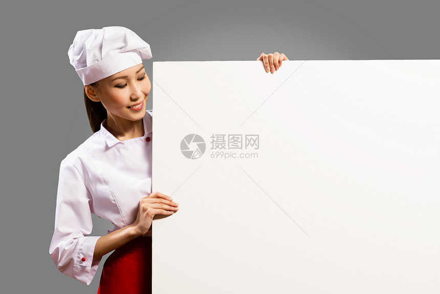 持有文本海报的女厨师女性微笑美食帽子广告工作室面包师木板食物菜单图片