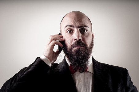 讲电话的长胡子男红色商业呼唤夹克人士男人工作室胡须男性领带背景图片