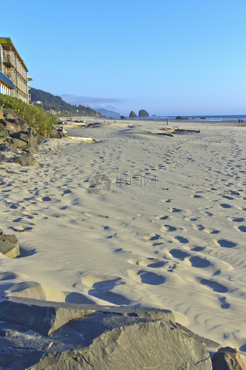 俄勒冈州卡农海滩的沙脚印植被旅游天空酒店岩石闲暇日志山脉旅行散步图片