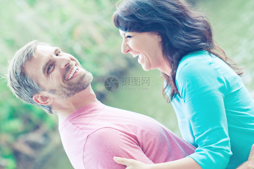 快乐的情侣头发女孩家庭男人微笑卷曲蓝色女性公园拥抱图片
