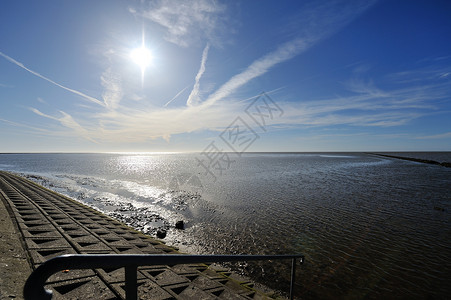 泥积平滑太阳天空栏杆蓝色海岸假期海滩轨迹淤泥支撑背景图片