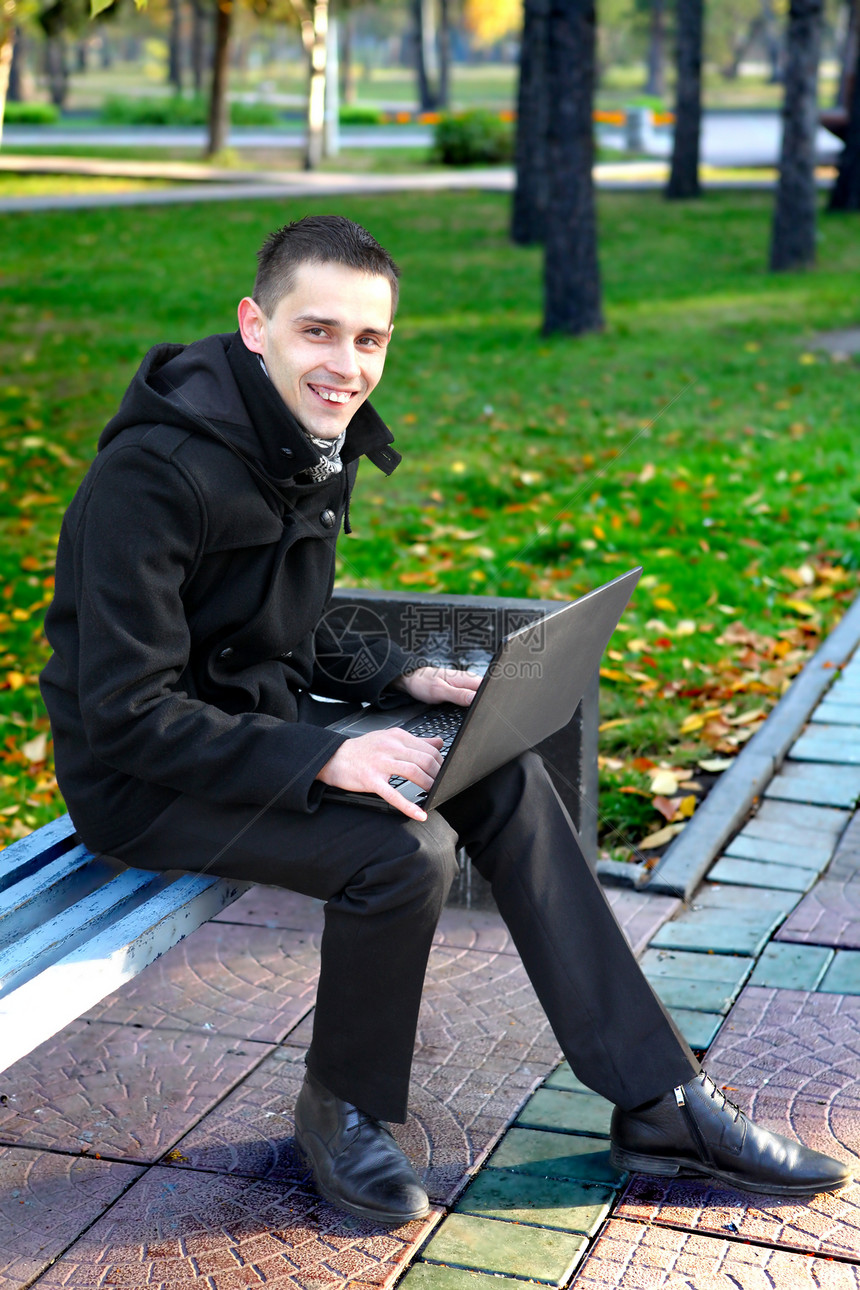 公园里有笔记本电脑的人操作工作长椅胡同叶子树木工具成人快乐互联网图片