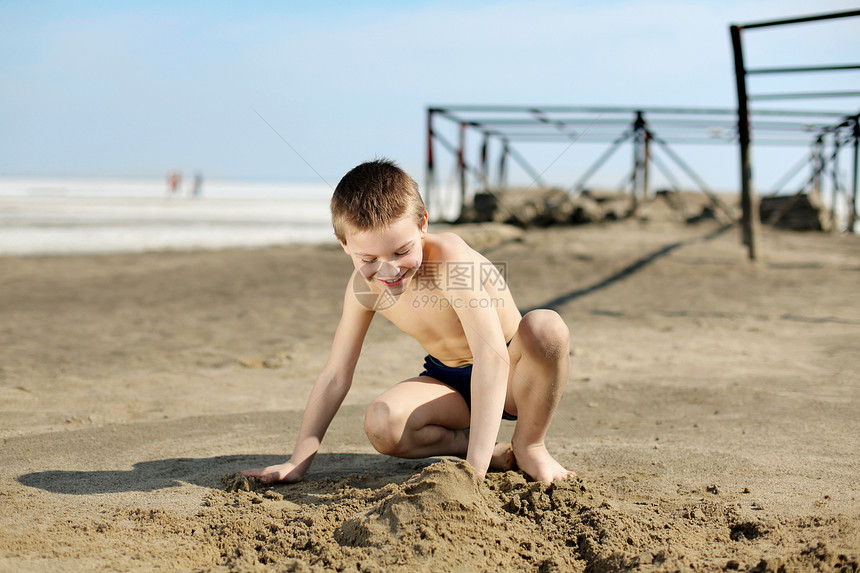 男孩在海滩上喜悦蓝色工业快乐青年男生天空阳光城堡男性图片