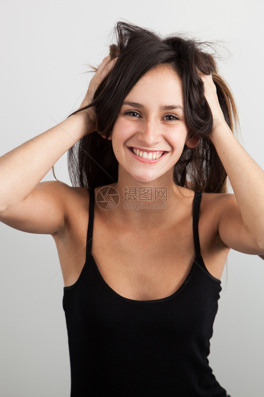 美丽的年轻女士在头发上玩耍图片
