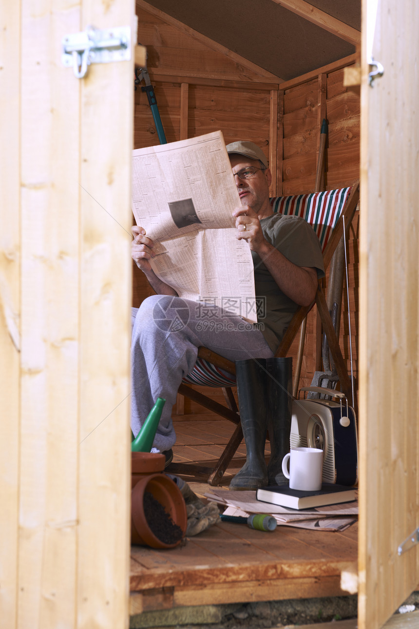 男人在花园小棚里读书工具园艺木头退休花园躺椅孤独报纸家庭生活学习图片