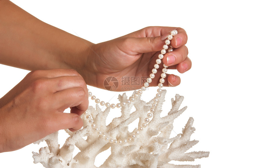 一只珍珠项链 在珊瑚的边缘放在她手中海洋白色珠宝图片