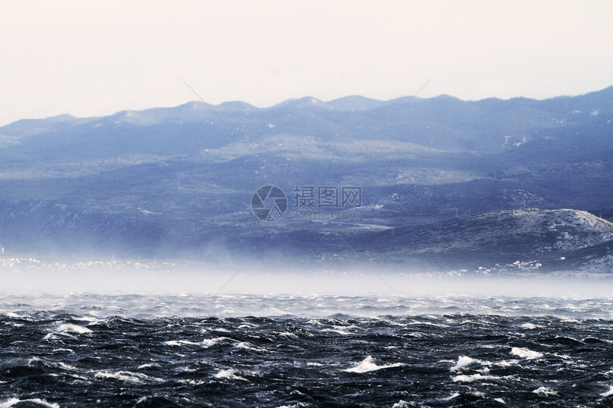 狂浪笼罩着大海海浪危险阳光蓝色愤怒爬坡雷雨天气戏剧性风暴图片