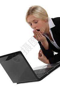 妇女当着电脑的面打哈欠白衬衫女士女性眼睛姿势衬衫桌子金发女郎手肘头发背景图片