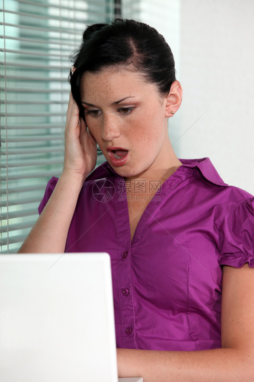 妇女张开嘴 对她的电脑感到震惊图片