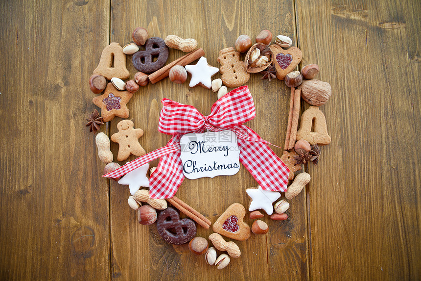 圣诞节用饼干和坚果做成的心形框架乡村糖衣花生八角开心果姜饼人巧克力丝带玻璃窗肉桂图片