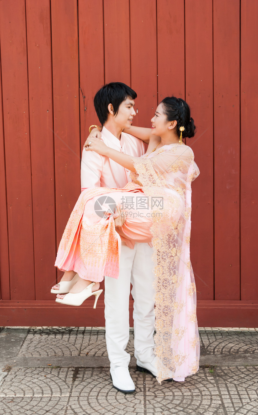 亚洲泰式吉里雅格罗 幸福中带可爱新娘女士男朋友文化男人戏服情人女性微笑粉色丈夫图片
